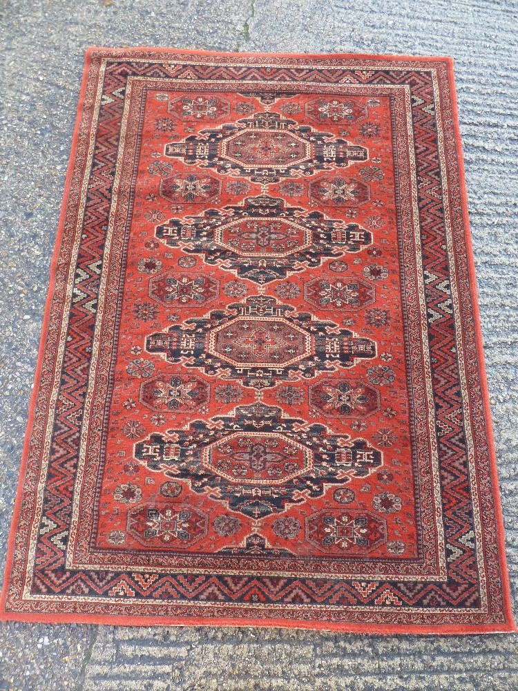 A Royal Keshan Soumac wool carpet red ground with repeating pattern and border, label to verso,
