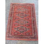 A Royal Keshan Soumac wool carpet red ground with repeating pattern and border, label to verso,