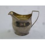 A George III silver cream jug, oval, angled handle, prick engraved sides, London 1803