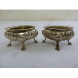 A pair of early Victorian silver salt cellars, oval, fluted with gadrooned borders on four stepped