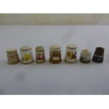 A quantity of English porcelain thimbles and a silver and enamel Russian thimble