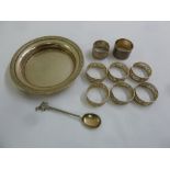 A quantity of white metal to include a circular dish, eight napkin rings and a spoon