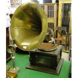 A wind-up gramophone player on oak stand, with brass horn.