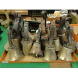 A set of brass hand bells with leather straps.