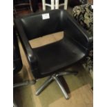 A black leather and chrome adjustable swivel chair.