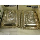 A pair of silver plated entree dishes and lids.