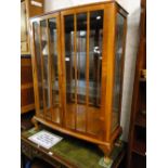 A walnut bow front 2-door display cabinet.