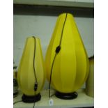 Pair of graduated table lamps with yellow fabric shades.