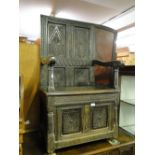 An Antique carved and panelled oak settle.