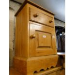 A pine bedside cabinet.