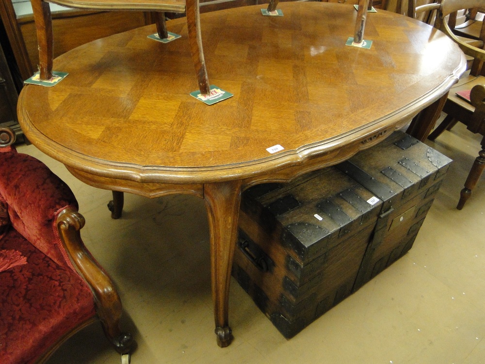 A French parquetry topped oak oval dining table on cabriole legs.