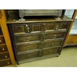 A square oak chest, having 2 linen fold panelled short drawers with long drawers under.