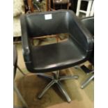 A black leather and chrome adjustable swivel armchair.