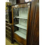An Edwardian mahogany serpentine front glass display cabinet.