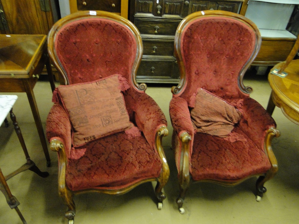 Pair of Victorian button back upholstered armchairs with carved mahogany showwood.