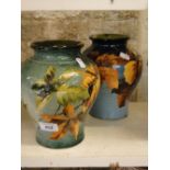 A pair of Art Pottery vases with foliate designs.