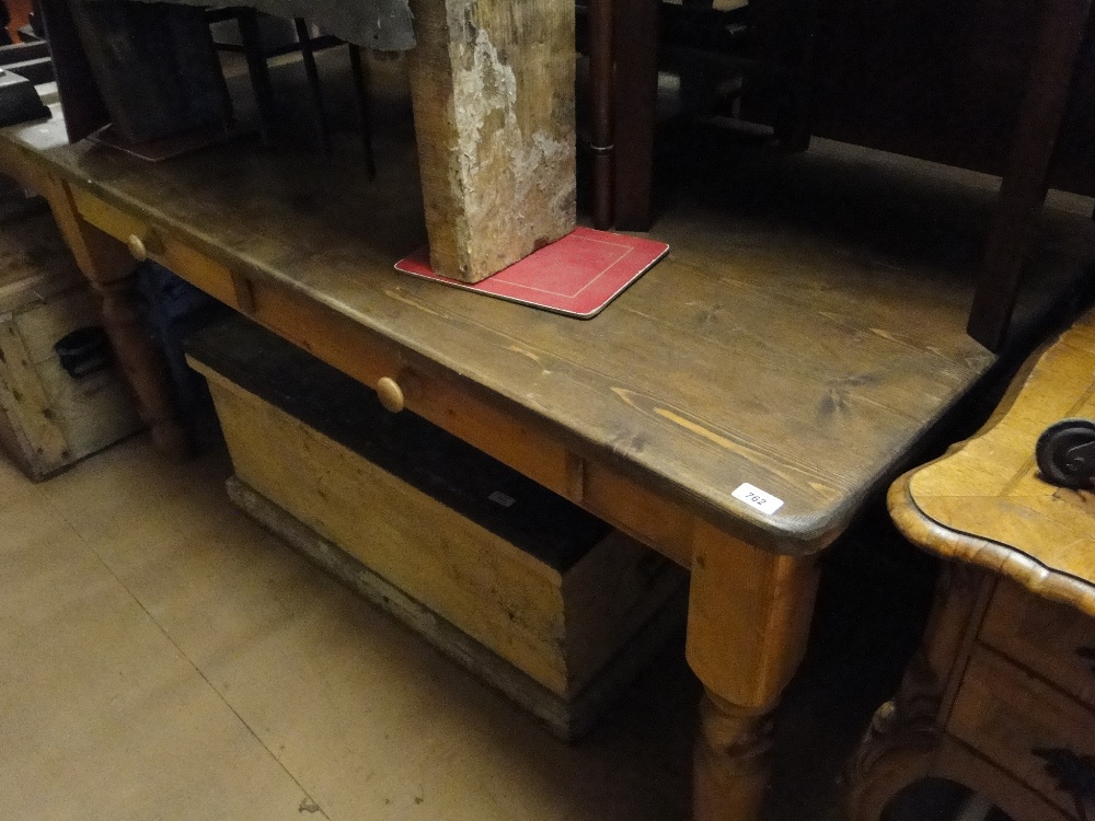 A rectangular pine kitchen table on turned legs with 2 frieze drawers.