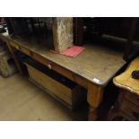 A rectangular pine kitchen table on turned legs with 2 frieze drawers.