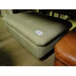 A large upholstered footstool.