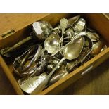 A box with silver teaspoons, sugar tongs, baby's rattle, chains, etc.