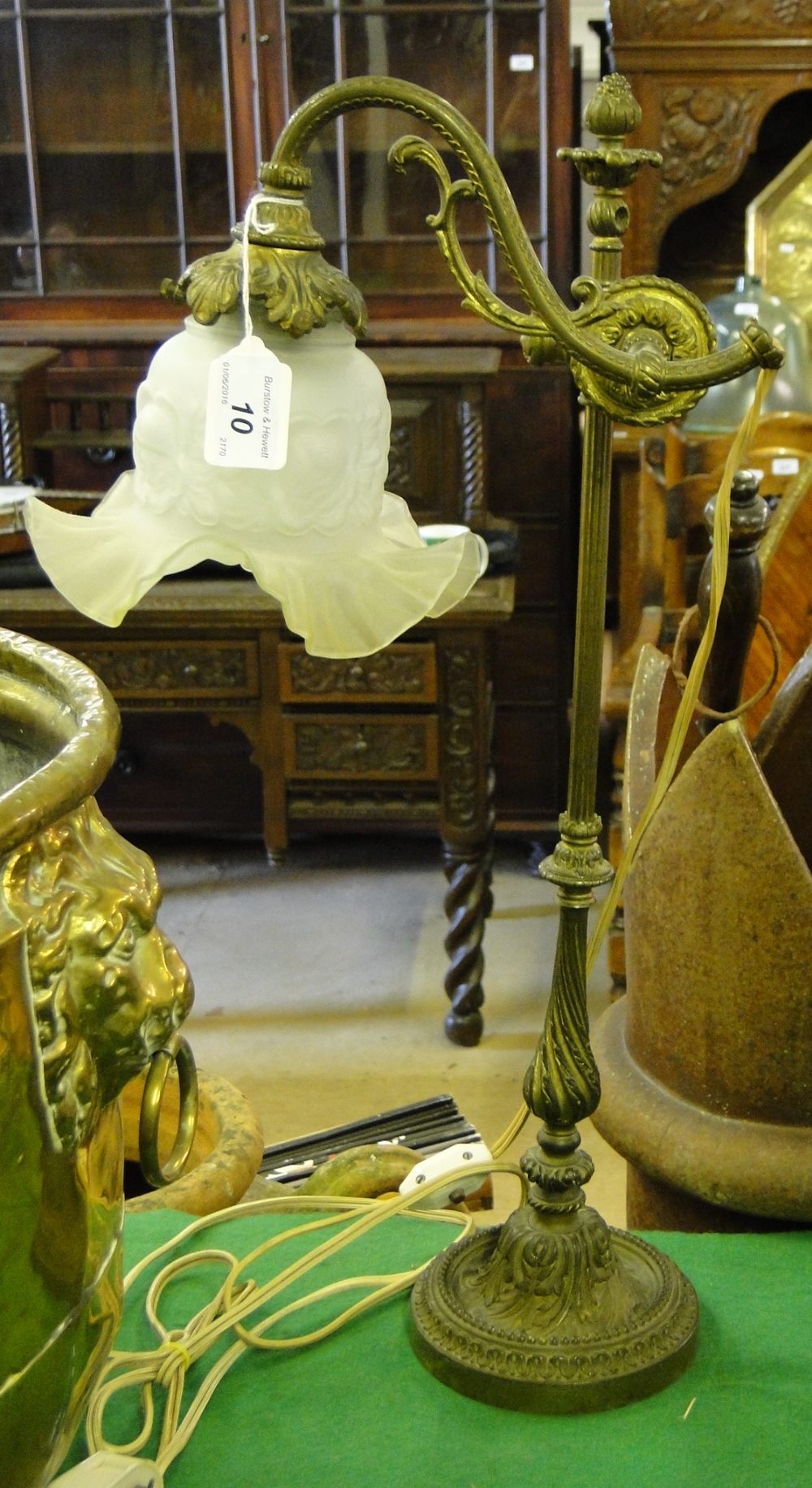 An ornate Victorian gilt brass desk lamp with rise and fall action and original frilled glass shade.
