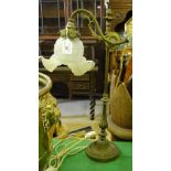 An ornate Victorian gilt brass desk lamp with rise and fall action and original frilled glass shade.