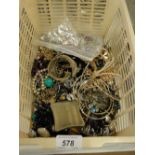 A basket of mixed costume jewellery, compacts, etc.