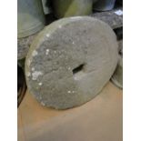 A weathered concrete millstone.
