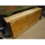 A large polished pine blanket chest.