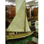 A painted wooden pond yacht with sails