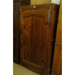 An Antique continental fruitwood cupboard with single panelled door.