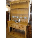 A polished pine dresser, with open plate rack 3 drawers and pot board below,