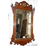 A Georgian walnut and gilt wall mirror with carved pediment.
