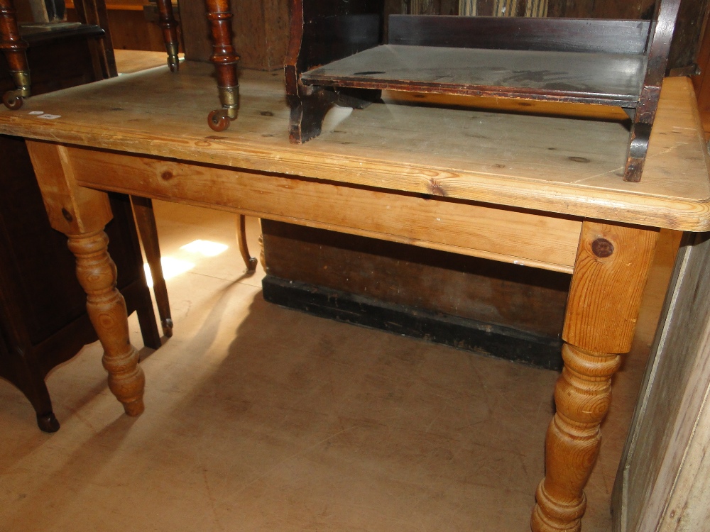 A rectangular pine kitchen table with baluster turned legs.