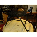 A black wrought iron Romanesque stool