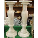 A pair of alabaster lamp stands with separate tops.