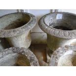 Pair of weathered concrete fluted garden urns.