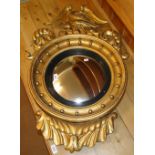 A 19th century carved giltwood Empire style convex wall mirror with Phoenix pediment