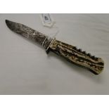A hunting knife by Solingen, with carved horn handle and inset knives and corkscrew,