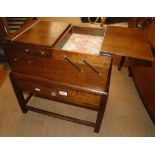An oak cantilever sewing cabinet.