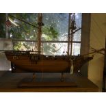 A wooden model of a 2 masted sailing ship with rigging.