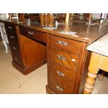 An Edwardian oak pedestal desk, having fitted drawers and cupboard.