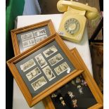 A cream dial telephone and framed cigarette cards and golly badges.