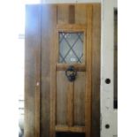 A hardwood panelled front door with small lead light glazed panel.