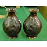 A pair of Oriental bronze vases with floral design.