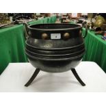 A Victorian steel cauldron with brass ring handles.