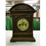 A German 2-train mantel clock in carved wood case with foliate designs.