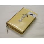 An ivory covered prayer book with silver cross.