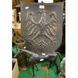 A copper German eagle emblem plaque, a brass easel, a pipe, and a brass horse.