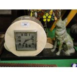 A French Art Deco marble mantel clock surmounted by a spelter figure of an Alsatian dog.